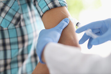 Doctor gives patient an injection in shoulder