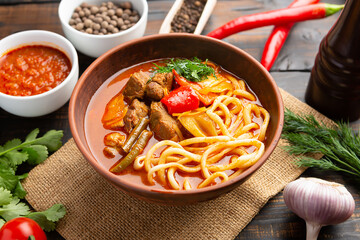 Lagman soup from middle Asia on dark wooden background