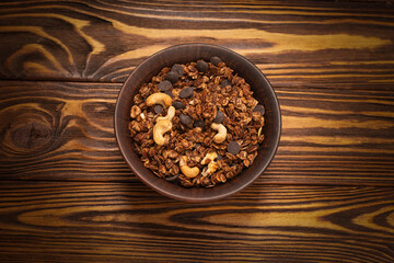 Chocolate granola cereal with nuts in a bowl.