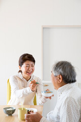 Obraz na płótnie Canvas 食事介助する日本人のミドル女性、在宅介助、ヘルパー