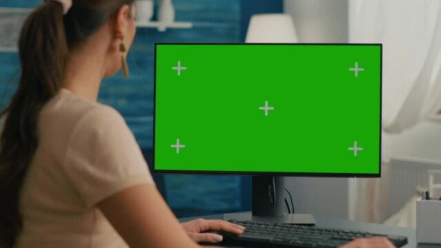 Close up of business woman use personal computer with mock up green screen chroma key. Freelancer sitting on chair at office desk working at financial graphs using isolated pc