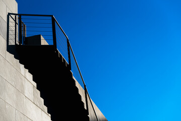 A stone  staircase of modern design, with lots of copy space on the blue sky background.