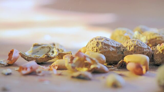 Detail of shell peanuts and out with pieces of shell falling from above