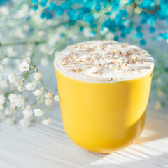 frappe for breakfast with flowers on a white board in a yellow cup