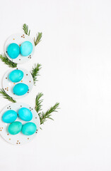 Colored eggs on plate with on white background. Flat lay. Copy space.  Easter concept. Top view.