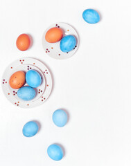 Colored eggs on plate with on white background. Flat lay. Copy space.  Easter concept. Top view.