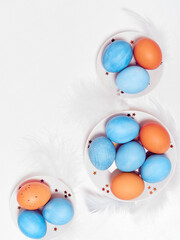 Colored eggs on plate with on white background. Flat lay. Copy space.  Easter concept. Top view.