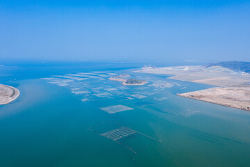Fototapeta na wymiar Aerial view of ocean, coastline and marine farms in Fujian, China, against blue sky