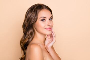 Photo of young beautiful lovely smiling woman naked shoulders apply skin product isolated on beige color background