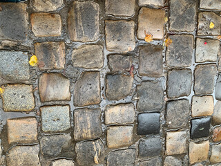 Wet cobbled sidewalk of granite stones
