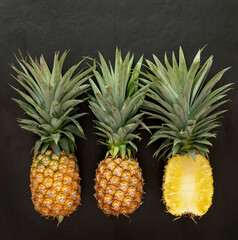 Obraz premium pineapple on the black texture background. .have a lot of fiber,vitamins C and minerals. food, fruits or healthcare concept.