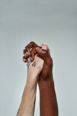 Multiracial hands of couple clenched into lock