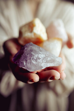 Young european girl holding a gemstone with boths hands in front of her.