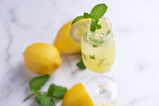 Fresh summer cocktail with lemons, mint and ice, selective focus image, Mojito in a glass cup, Fresh citrus lemonade with limes and lemons. Fresh and cool beverage for summer concept.