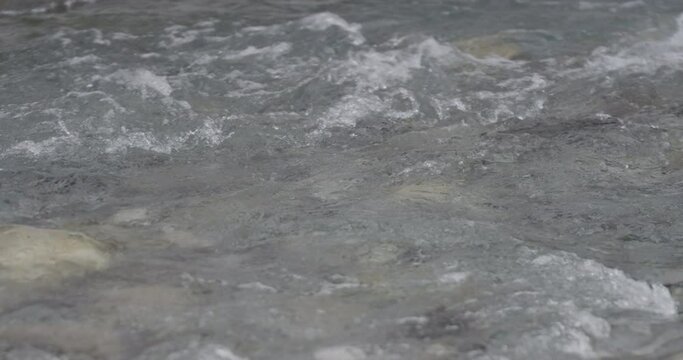 Close up of a mountain river stream with clear water at winter in slow motion