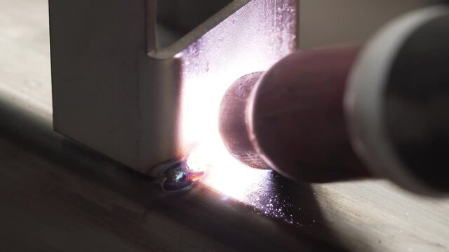 Professional male welder with gas tungsten arc welding (GTAW) or tungsten inert gas (TIG), Closeup shot
