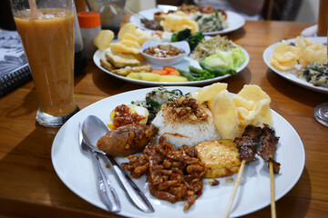 インドネシアのバリ島、ウブドの現地ワルンの食卓。ナシチャンプルー。フルーツジュース。ガドガド。