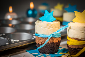 Detail of triple chocolate mini cake with blue and yellow decoration and muffin baking tray