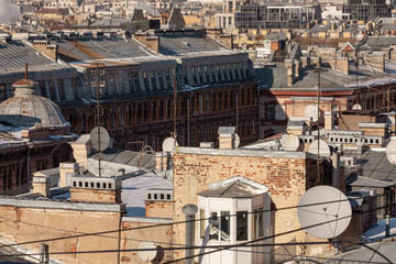 Multiple antennas on the roofs of the old buildings.