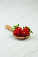 Stroberi or strawberries on wooden spoon with isolated white background. Bright photography concept, copy space for text.
