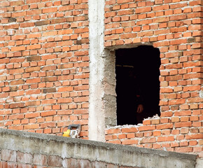 A square hole in the red brick wall