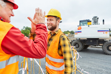 Bauarbeiter geben sich ein High Five auf der Baustelle