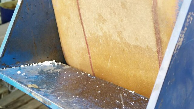 Male hands throw cartridges into the feed port of a plastic crusher in grinding machine. The concept of plastic shredding, recycling of raw materials, factories, industry and production