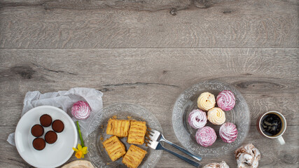 Border of various cookies, tarts, cakes and cup of coffee.  Wide banner.