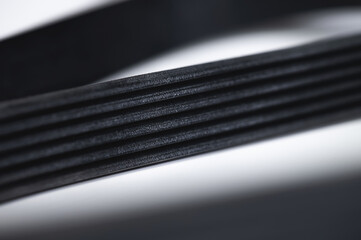 Close-up of a poly V-belt of a generator on a gray background in shallow depth of field. Background...