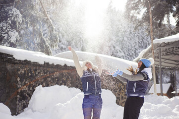 Two girlfriends have fun and enjoy fresh snow on a beautiful winter day