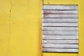 Banner of background of old dirty yellow wall with wooden slats