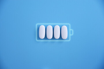 Battery and white pill medicine, energy for life, idea Battery charging symbol and capsules. Health and Technology, energy for life.