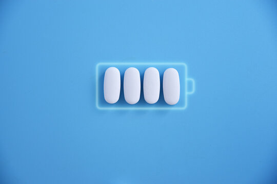 Battery and white pill medicine, energy for life, idea Battery charging symbol and capsules. Health and Technology, energy for life.