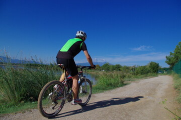 Fototapeta na wymiar Vélo cycliste sur une piste cyclable voie verte en pédalant sur une bicyclette