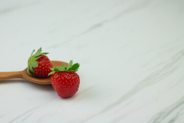 Stroberi or strawberries on wooden spoon with isolated white background. Bright photography concept, copy space for text.