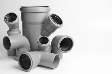 Fototapeta premium PVC plastic water pipes in gray color, insulated on a white background. The concept of installation, replacement of plastic pipes, plumbing. Copyspace.