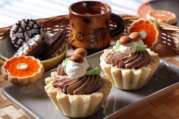 Close-up of different beautiful sweet cakes with cream and marmalade on the table