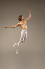 Aesthetic. Young and graceful ballet dancer isolated on studio background in flight, jump. Art,...