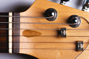 Close-up elements of electric guitar on gray background