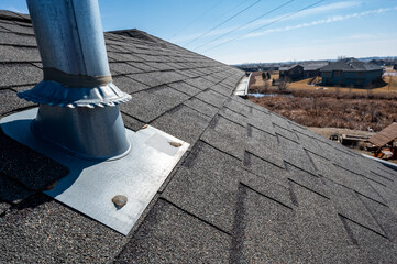 Flashing and weather sealing on vent chimney on a shingle roof © Lost_in_the_Midwest