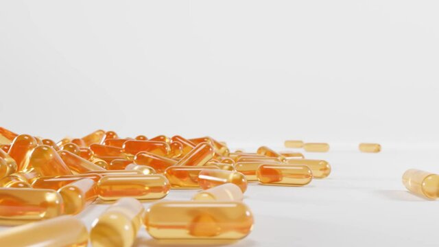 Golden transparent capsules of vitamin A, E, Omega 3 or collagen essence, serum gel. Medical pill with fish fat or organic cosmetic oil. Pile fall yellow orange tablets isolated on white background.