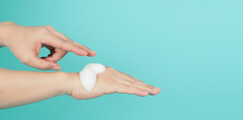 Hands washing gesture with foaming hand soap on green and Tiffany Blue  background.