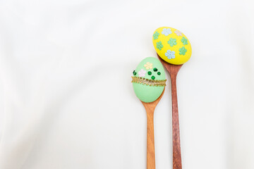 Beautiful green and yellow easter egg on white fabric fabric texture background, Happy easter card background idea