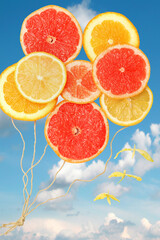 Vitamin flying fruit baloons and birds on a blue sky with clouds