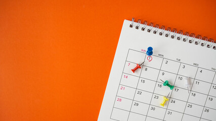 blue pin on 1st date of month with red circle on grunge orange background, panorama