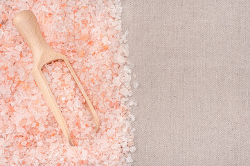 Himalayan crystal tibetan pink coarse sea salt in wooden scoop. Pink salt granules. Useful spa...