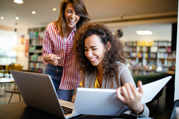 Group of college students studying in the school library.
