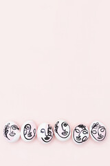 Happy Easter concept. Surreal faces on eggs on pink background. Art und Online style. Top view Flat lay Copy space