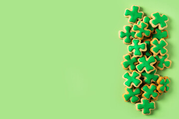 Saint Patrick's day concept with green cookies shamrock on green background,