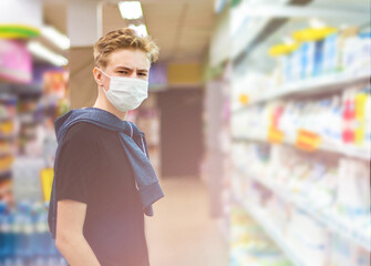 Fototapeta na wymiar Boy wears protected mask in store. Shopping time during coronavirus outbreak.Boy in a medical mask. Quarantine and protection virus, flu, epidemic COVID-19. Coronavirus quarantine.